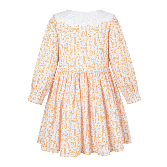 Back view of the Babycakes Smocked Dress in Tennessee, cream fabric with an orange hound and 'TN' motif print, white eyelet collar.